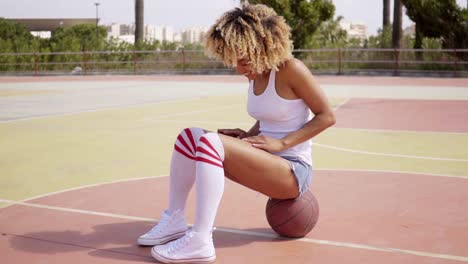 Blond-young-woman-sits-cross-legged-on-ball