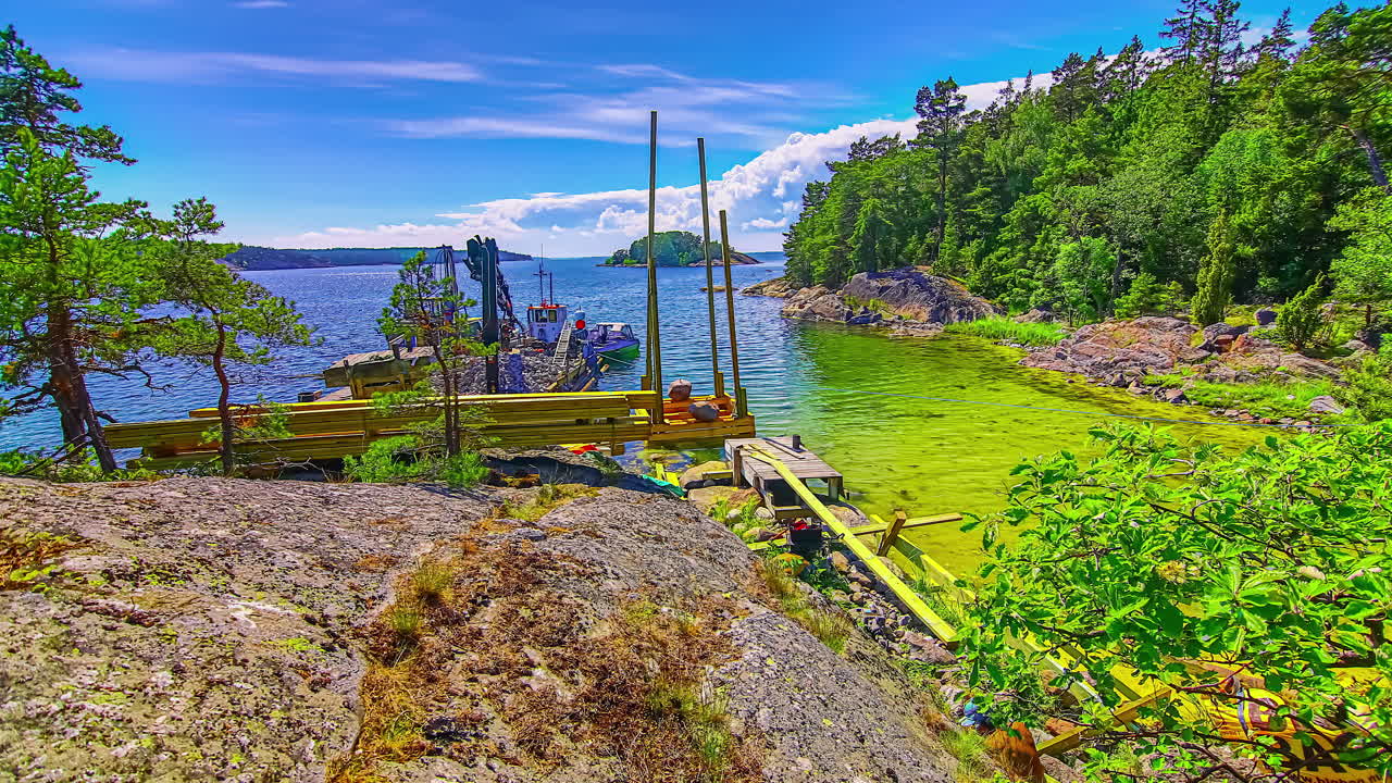 여름철 바다 위 바지선에 굴삭기로 작은 배를 위한 부두를 짓는 건설 인부들