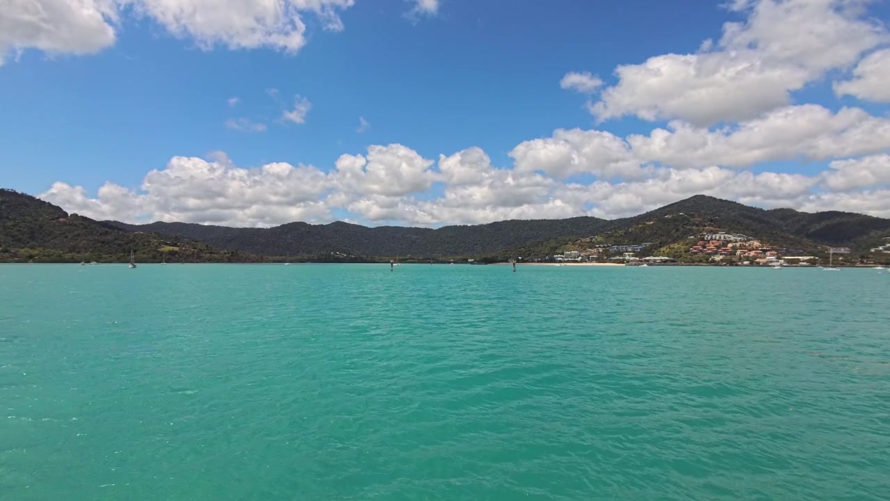 Pintoresca Bahía Tropical con Agua Turquesa, Montañas Verdes y Pueblo Costero