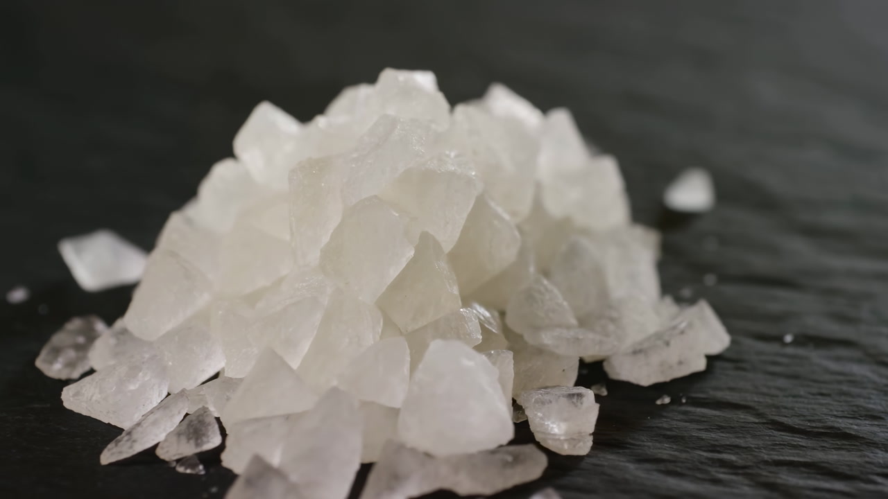Coarse Sea Salt Crystals On Slate, Shallow Depth Of Field Highlights Translucent Flakes And Rugged Texture,