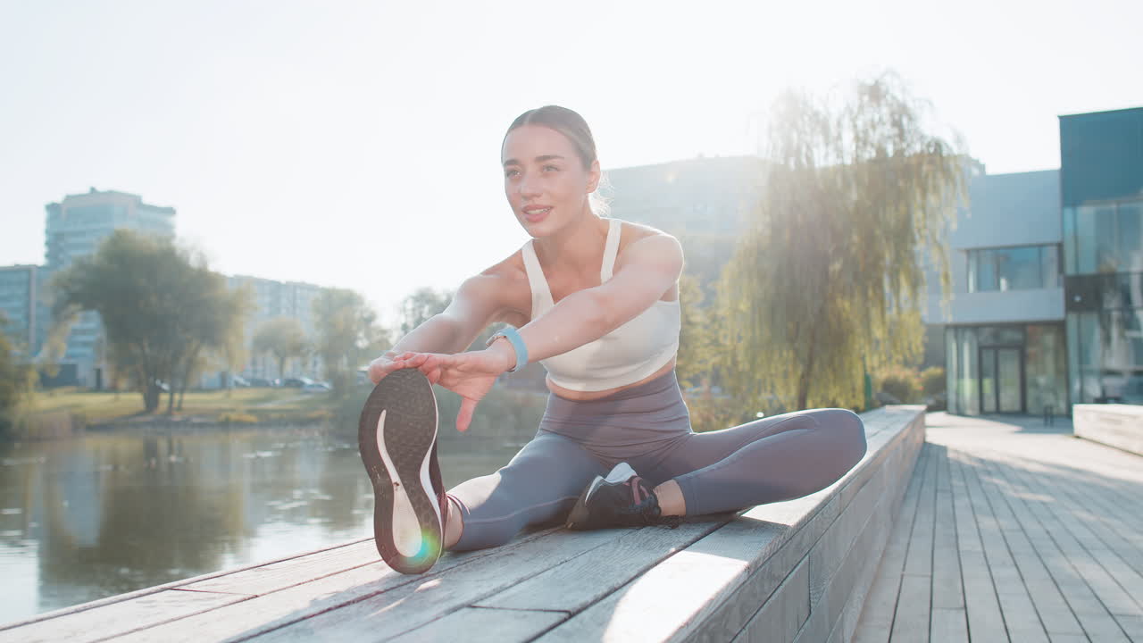 백인 젊은 여성이 피트니스, 건강 및 웰빙을 위해 도심 공원에서 다리를 펴고 있습니다.