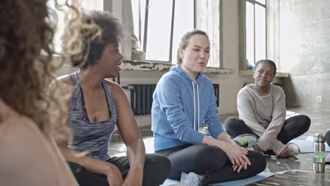 cheerful women chatting before yoga class