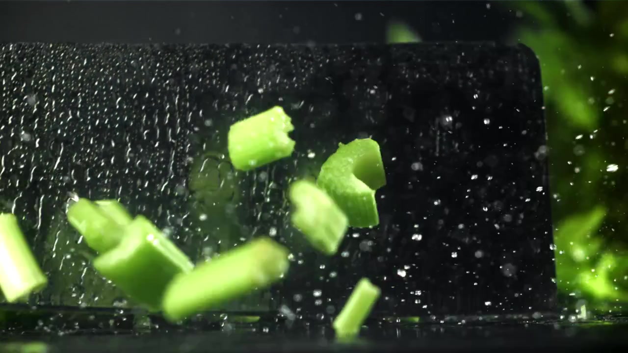 Slow Motion Chopping Fresh Green Celery with Water Splashes