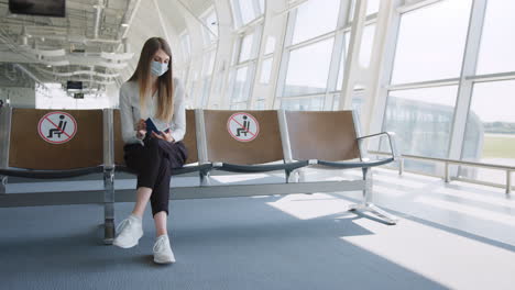 woman wearing mask waiting at airport