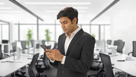 Angry-Indian-businessman-texting-someone