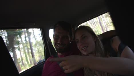 pareja hablando en el asiento trasero de un coche de conducción