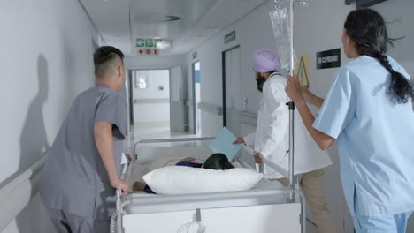 busy diverse doctor and surgeons walking with patient on hospital bed in slow motion