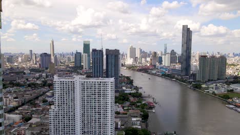 bangkok skyscrapers cityscape by chao phraya river, aerial sideways shot, thailand