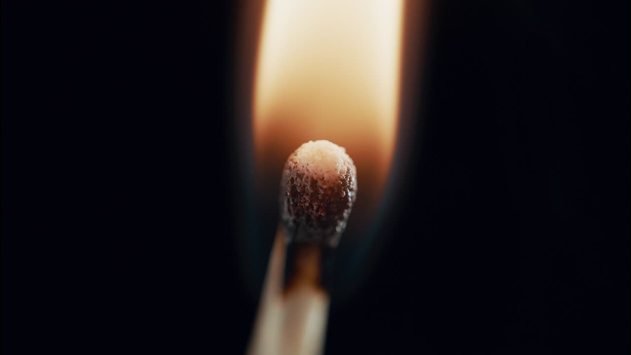 un fósforo sin encender se enciende en llamas en un primer plano extremo. se extingue y el humo gira hasta que se ha ido.