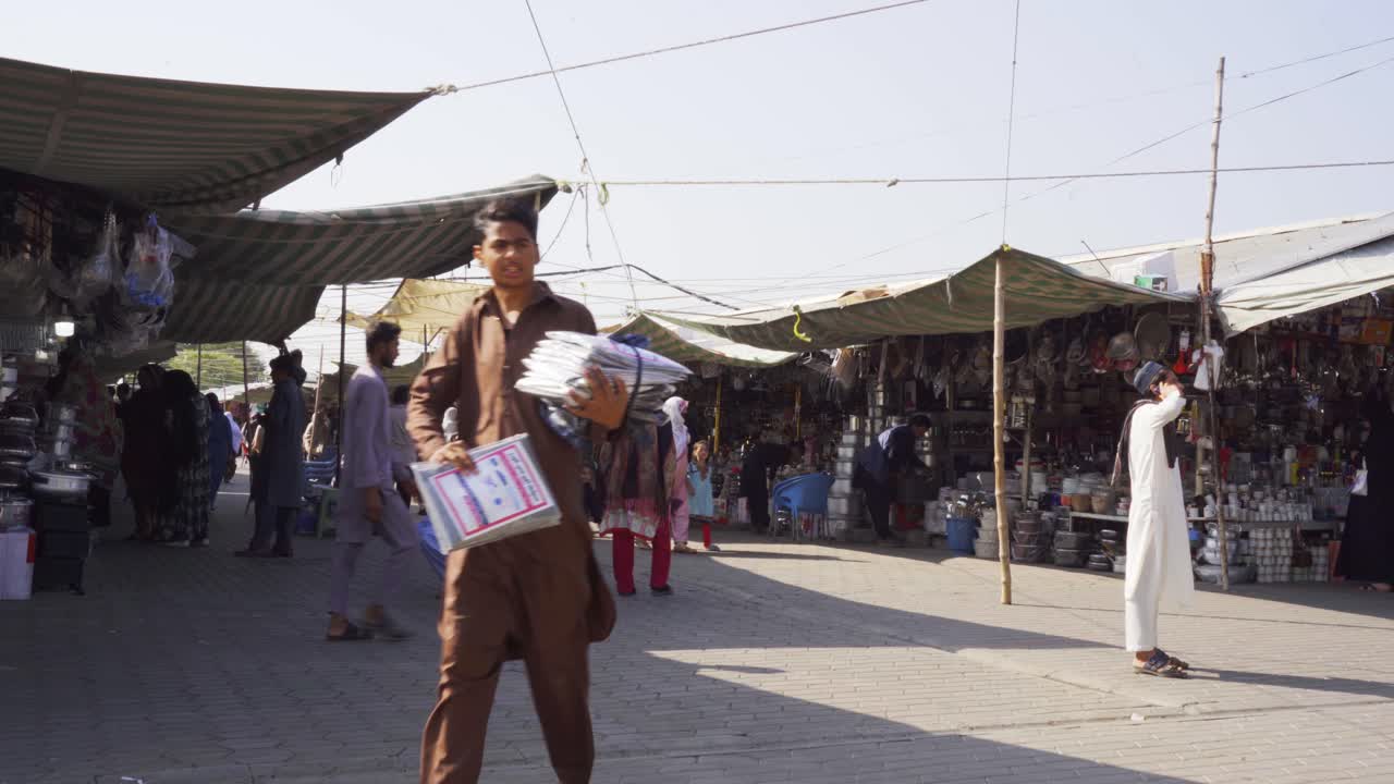 Bustling Islamabad market scene showcasing people engaged in lively haggling and shopping for essential groceries from street vendors and stalls.