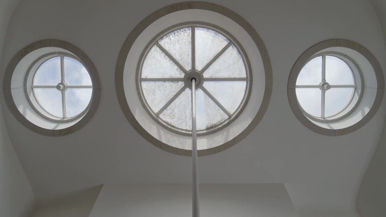 Displaying central skylight with pole at atrium ceiling, moisture moving on glass, and side windows