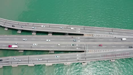 aerial top view of penang bridge first segment from the island with light bidirectional traffic, drone dolly left shot