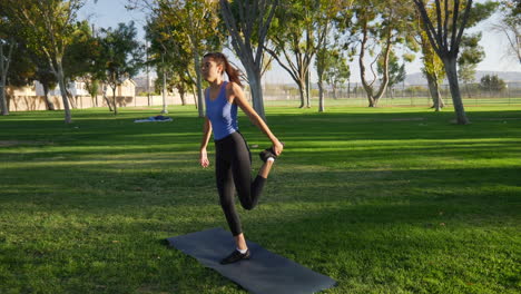 una mujer joven balanceándose y estirándose antes de su entrenamiento de yoga para mantenerse saludable y prevenir lesiones a cámara lenta