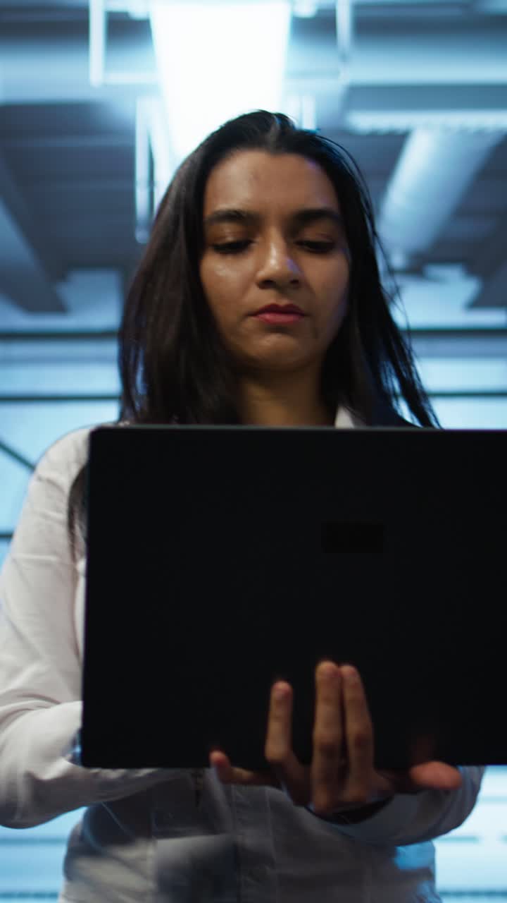 Young Woman Working on Laptop in Data Center
