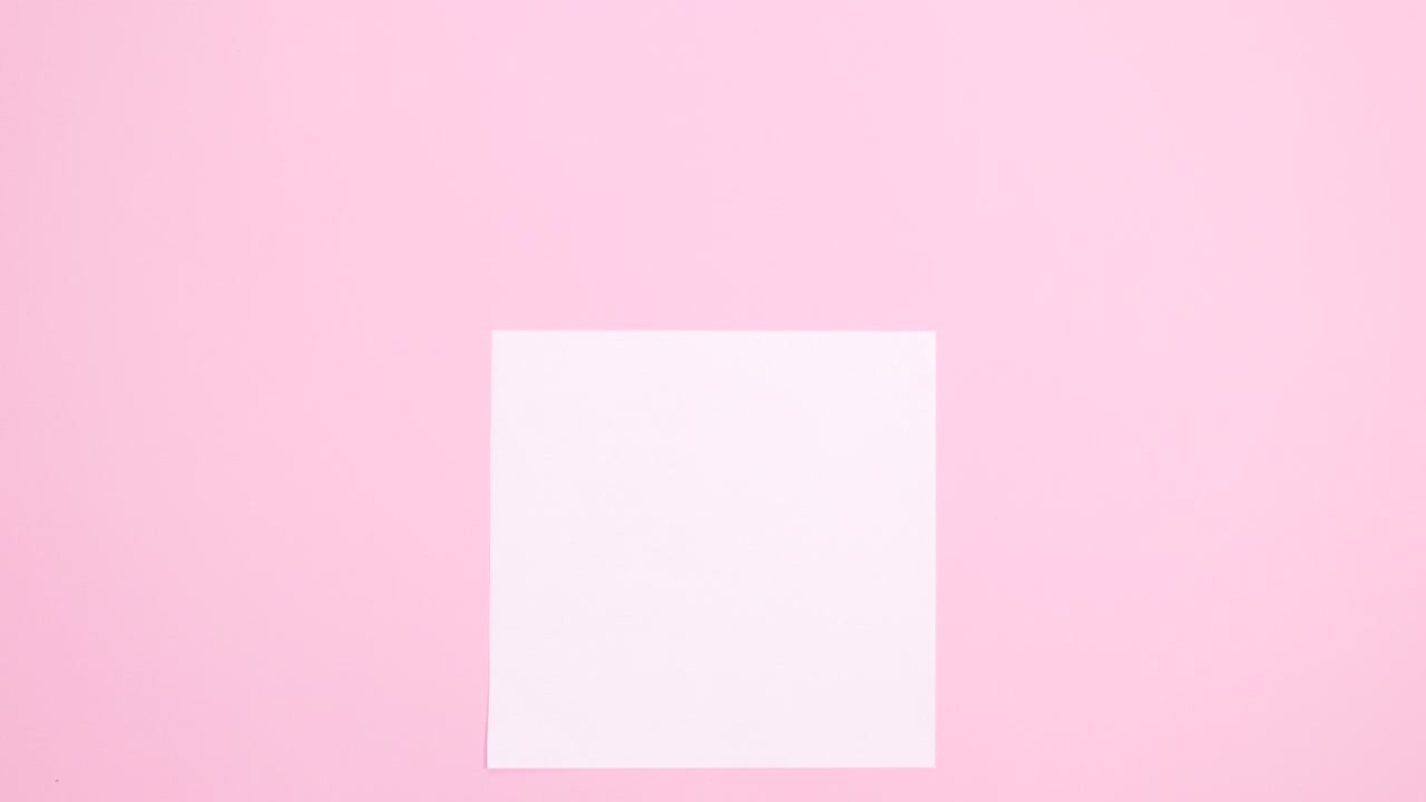 토끼 귀는 파스텔 분홍색 배경에 종이 카드 메모 아래에 나타납니다.