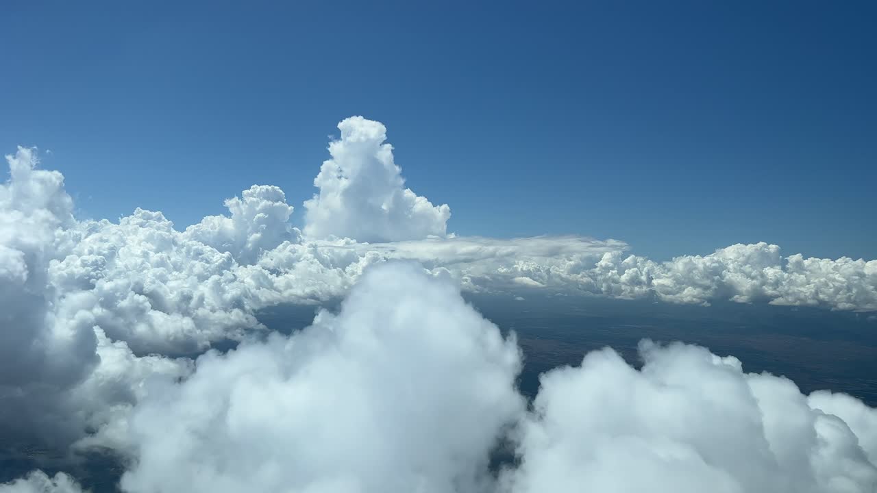 Unique pilot&rsquo;s point of view of a sky with some tiny clouds, shot from a jet&rsquo;s cabin while flying at 6000m high, with a deep blue sky