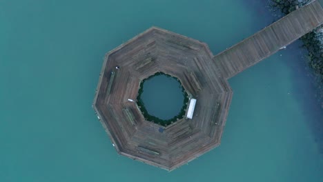 un muelle cerca de la costa para pescar y la inversión de la niebla temprano en la mañana