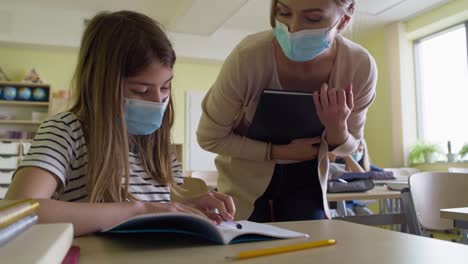 video de niños de escuela con las manos levantadas en el aula