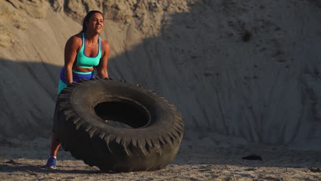 girl in sportswear pussh a tire. street workout.