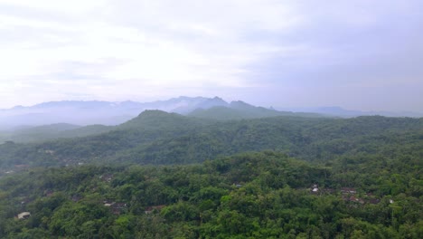 Luftaufnahme-Der-Naturlandschaft-Mit-Blick-Auf-Regenwald-Und-Hügel-Mit-Bewölktem-Himmel---Tropisches-Land