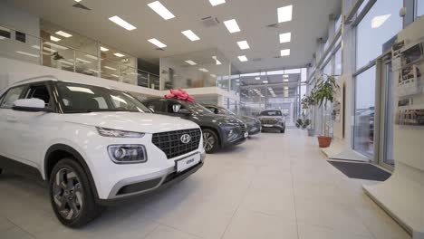 car dealership with row of anonymous new vehicle on sale. showroom with shiny auto. automotive