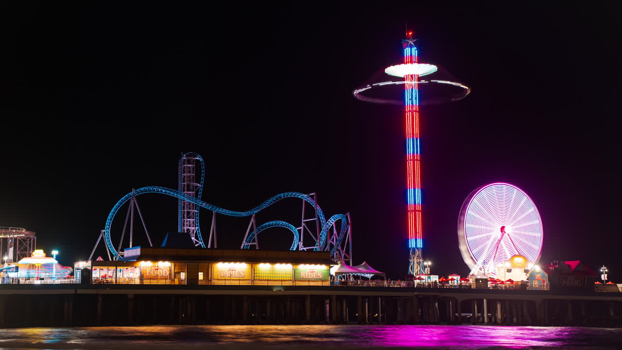 Rides at Galveston's Pleasure pier light up at night. Texas 2025
