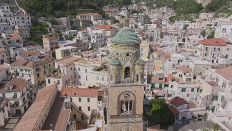 rotating aerial footage flying up around from the spire of a church, the duomo di amalfi in amalfi