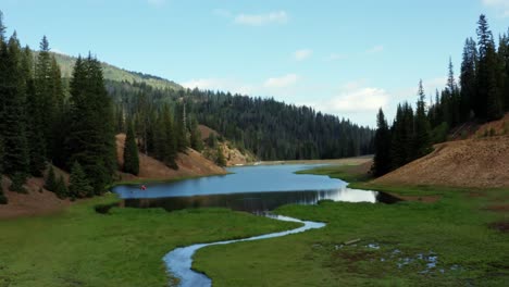 Hermosa-Toma-Aérea-De-Un-Dron-De-Un-Impresionante-Paisaje-Natural-Del-Lago-Del-Embalse-Del-Prado-Anderson-Hasta-El-Cañón-Del-Castor-En-Utah-Con-Un-Gran-Bosque-De-Pinos,-Un-Pequeño-Arroyo-Y-Un-Campo-De-Hierba