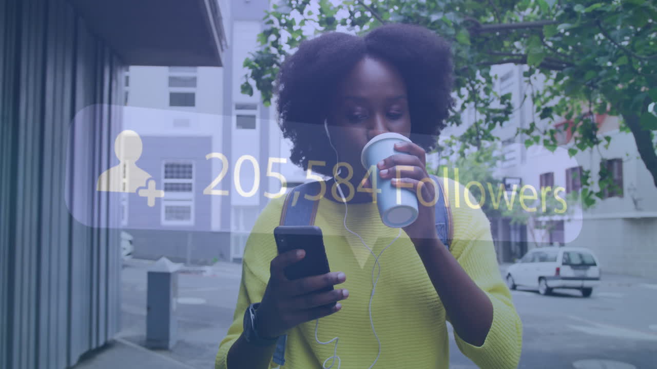 Animation of social media notification over african american woman using smartphone in city street