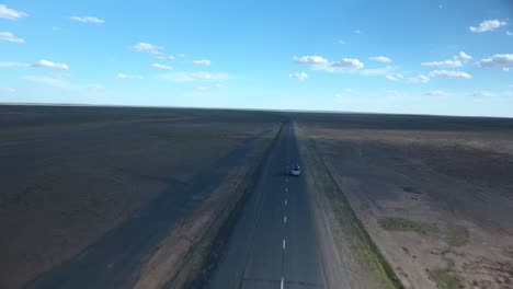 disparo aéreo de un avión no tripulado siguiendo una furgoneta en una carretera desierta en mongolia