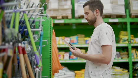 hombre comprando herramientas de jardín en una tienda