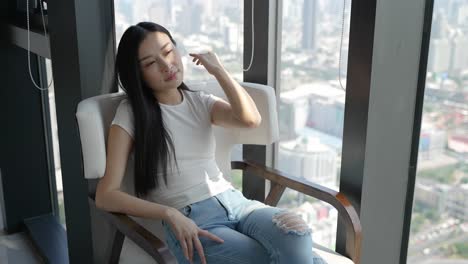 woman sitting by window with city view