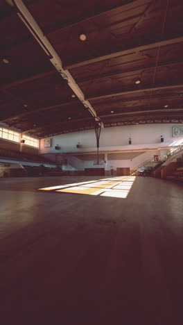 empty basketball court with sunlight shining through the windows