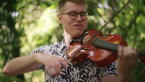 Close-up-Joven-Talentoso-Violinista-Tocando-El-Violín-En-La-Naturaleza,-Enfoque-Superficial