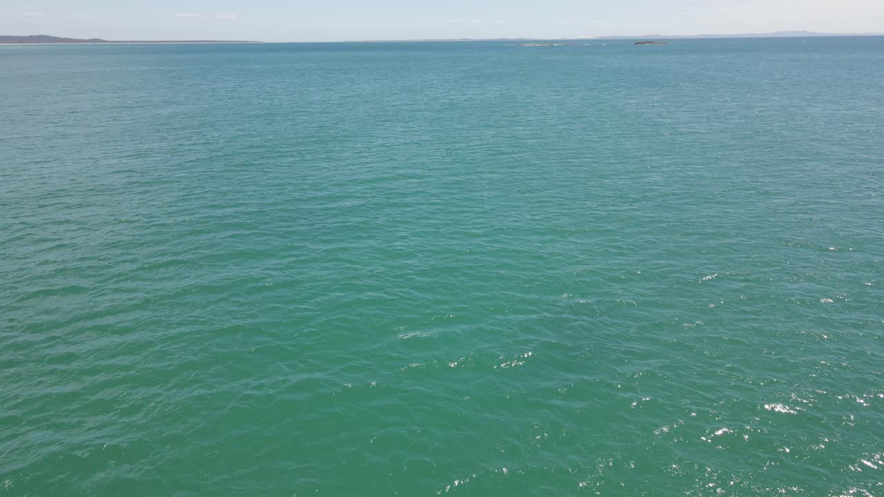 스쿠버 다이버들이 호주 퀸즐랜드의 노스 스트래드브로크 섬 해안에서 깊고 푸른 바다로 다이빙합니다.