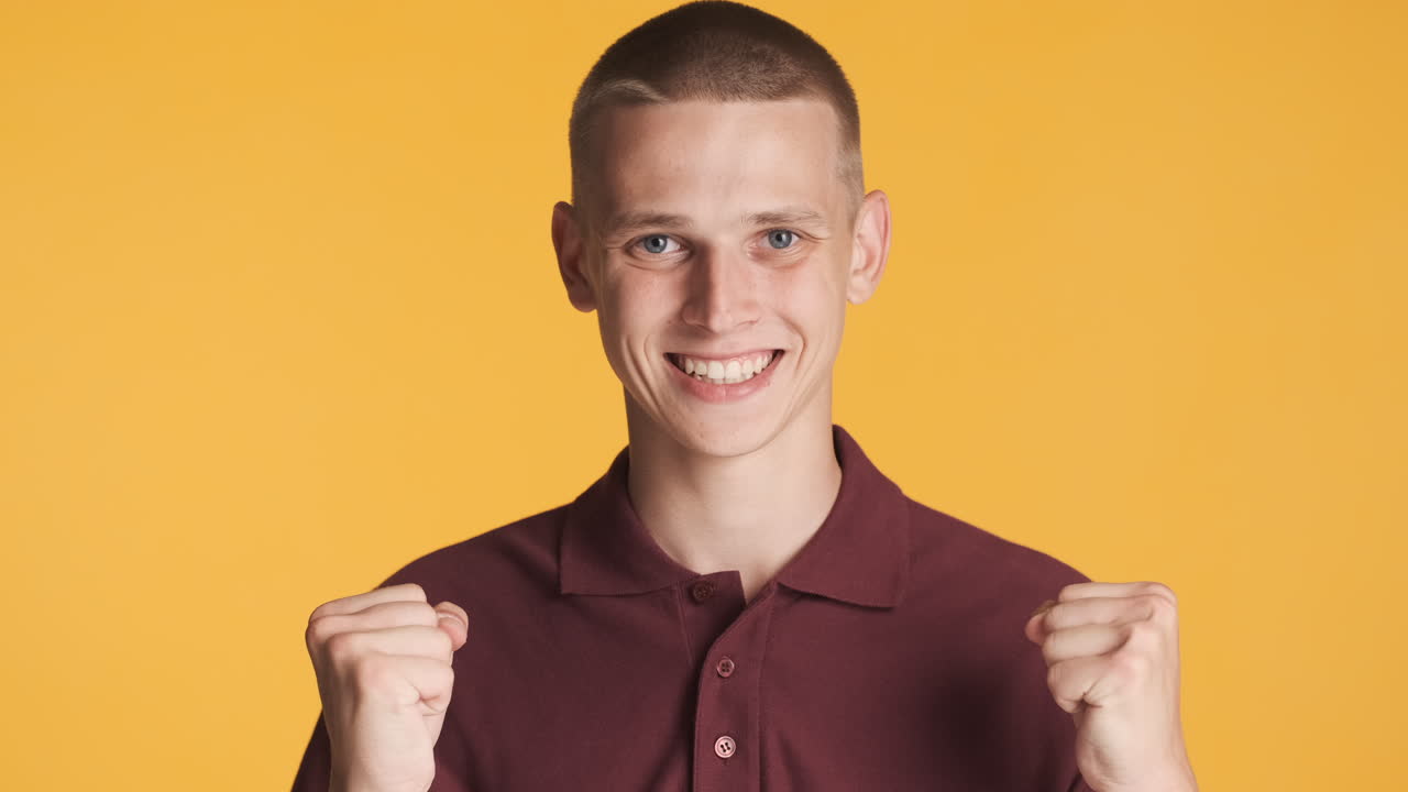 Young man celebrating and giving thumbs up