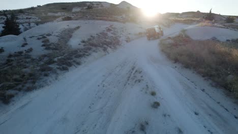 land rover cruising through desert during sunset