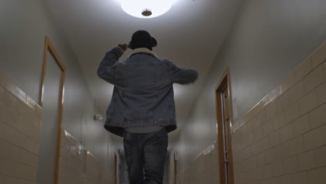 African-American-man-walking-down-a-long-hallway