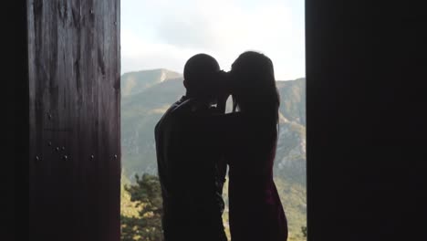 couple kissing at doorway with mountain view