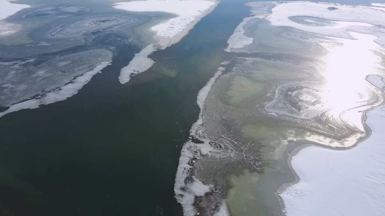 Donmuş kış nehri gölü üzerinde ilkbahar buz sürüklenmesi havadan çekimi - Drone Koleksiyonu stok video.