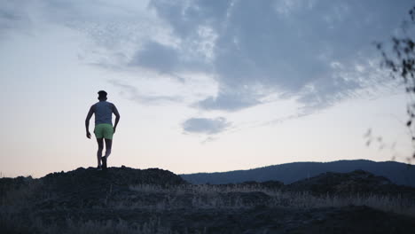 slow motion trail runner reaches mountain summit at dawn, fitness concept