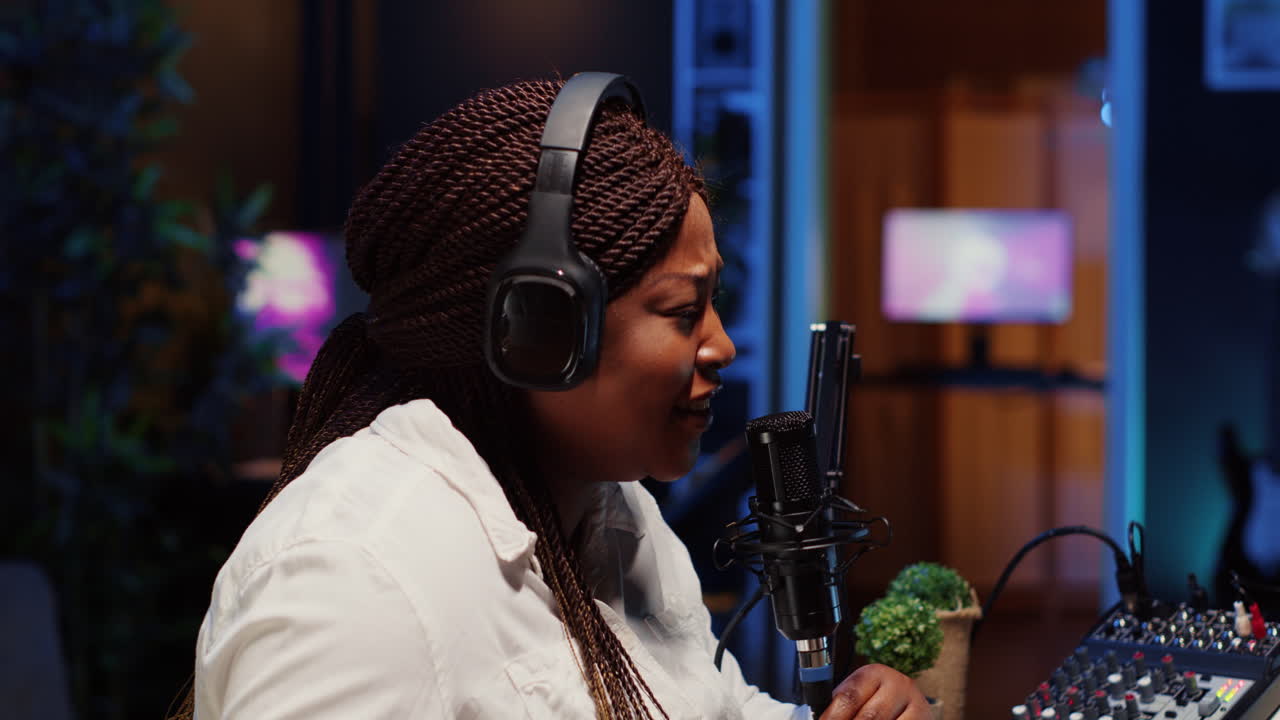 Woman recording podcast, adjusting mic to ensure optimum sound quality