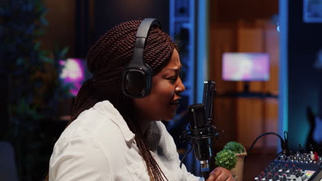 woman recording podcast, adjusting mic to ensure optimum sound quality