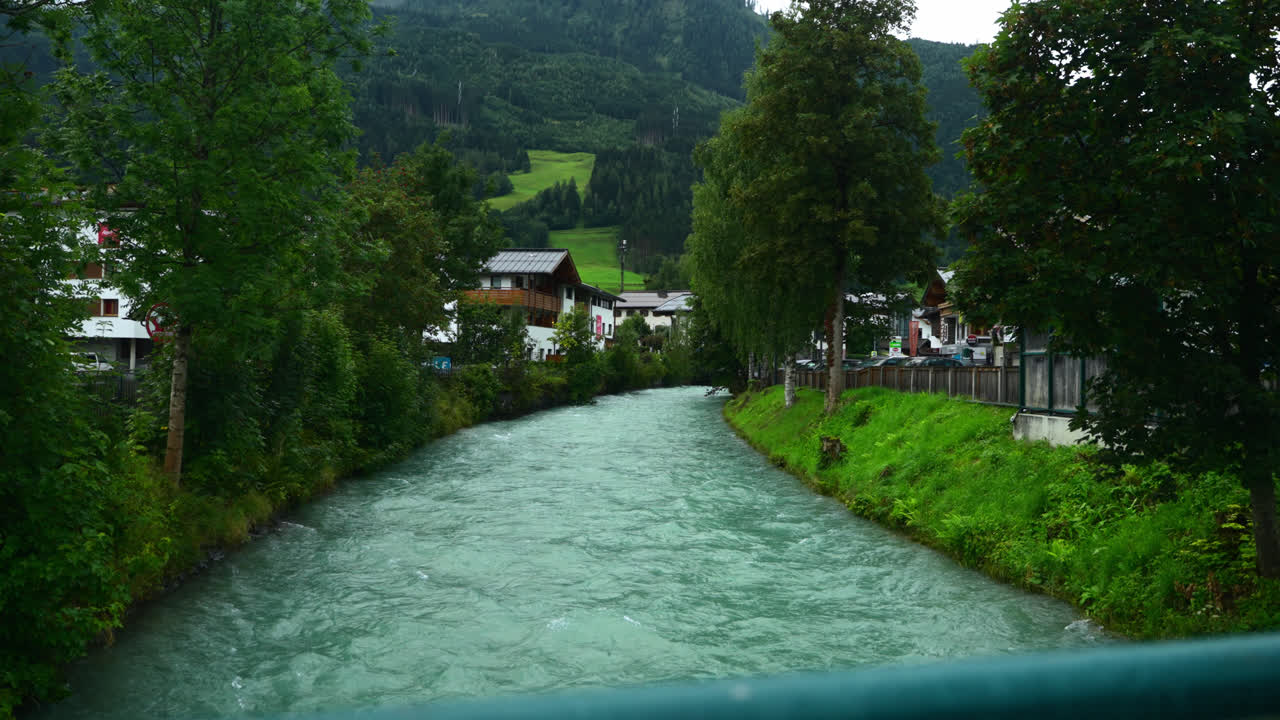 Fiume glaciale blu che scorre attraverso il paesaggio verde di Kaprun, Austria, al rallentatore