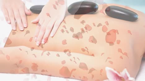 mujer teniendo un masaje con piedras calientes