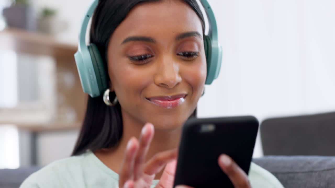 Donna, musica in cuffia e social media con il telefono