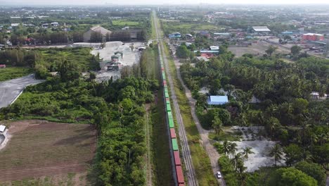 wonderful view of a colorful train surrounded by green trees - aerial shot