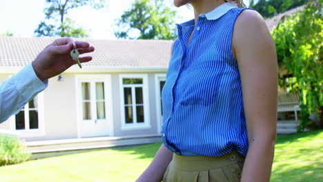 close up of man giving house''s keys to smiling woman