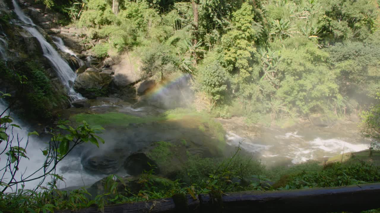Majestic Waterfall in a Lush Green Forest with a Rainbow Mist