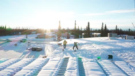 two men shoveling the snow off the roof of a local business warehouse in soldotna, alaska